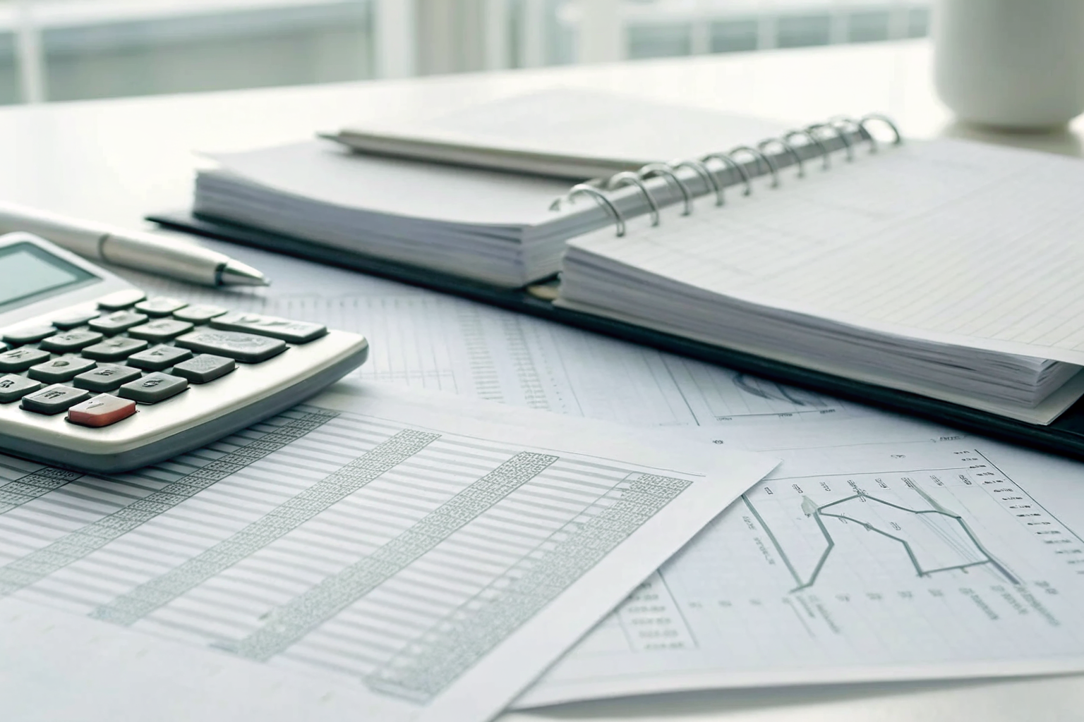 Calculator and financial documents on a desk showing ad budget.