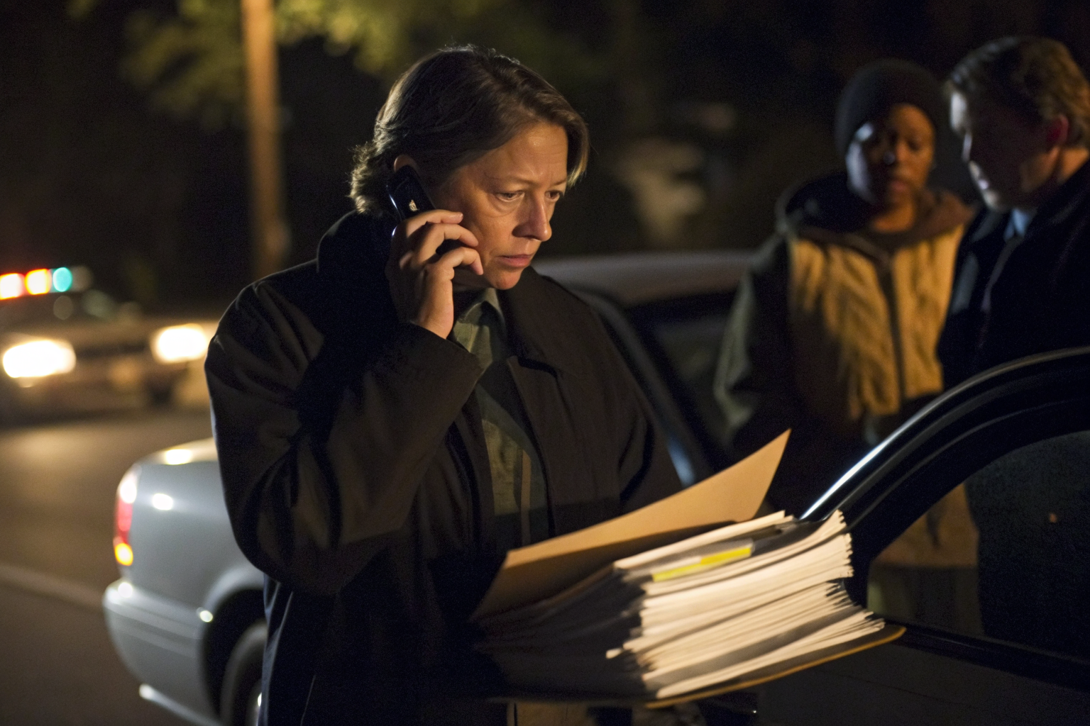 Person making a phone call at night surrounded by legal documents.