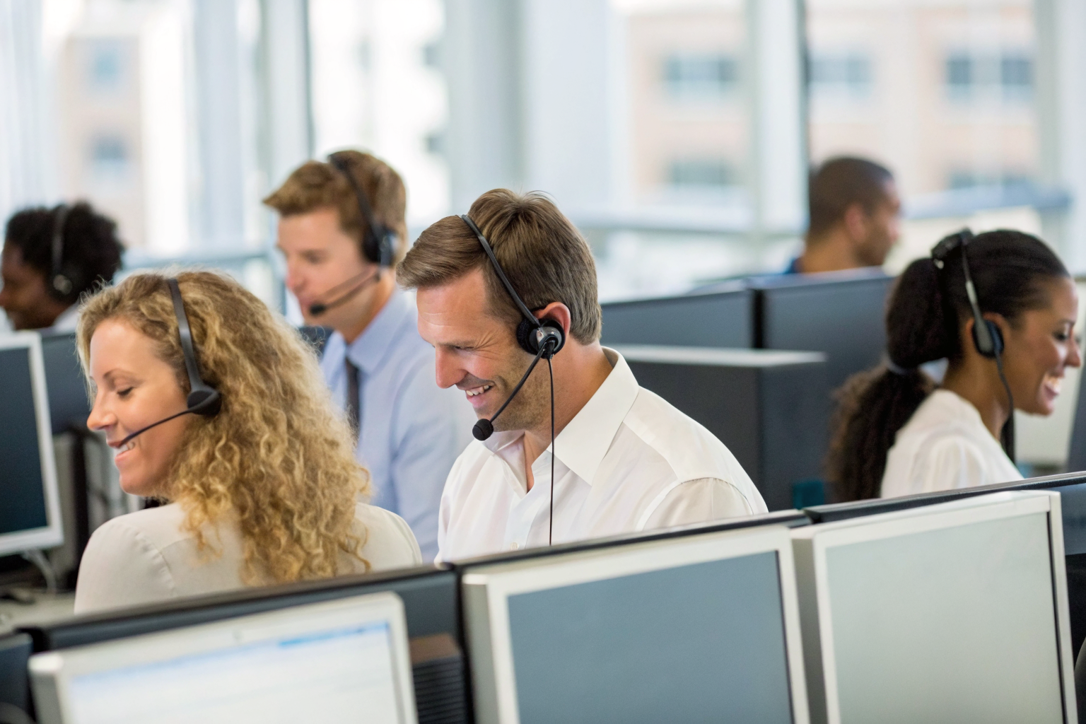 Call center with agents and screens showing error alerts.