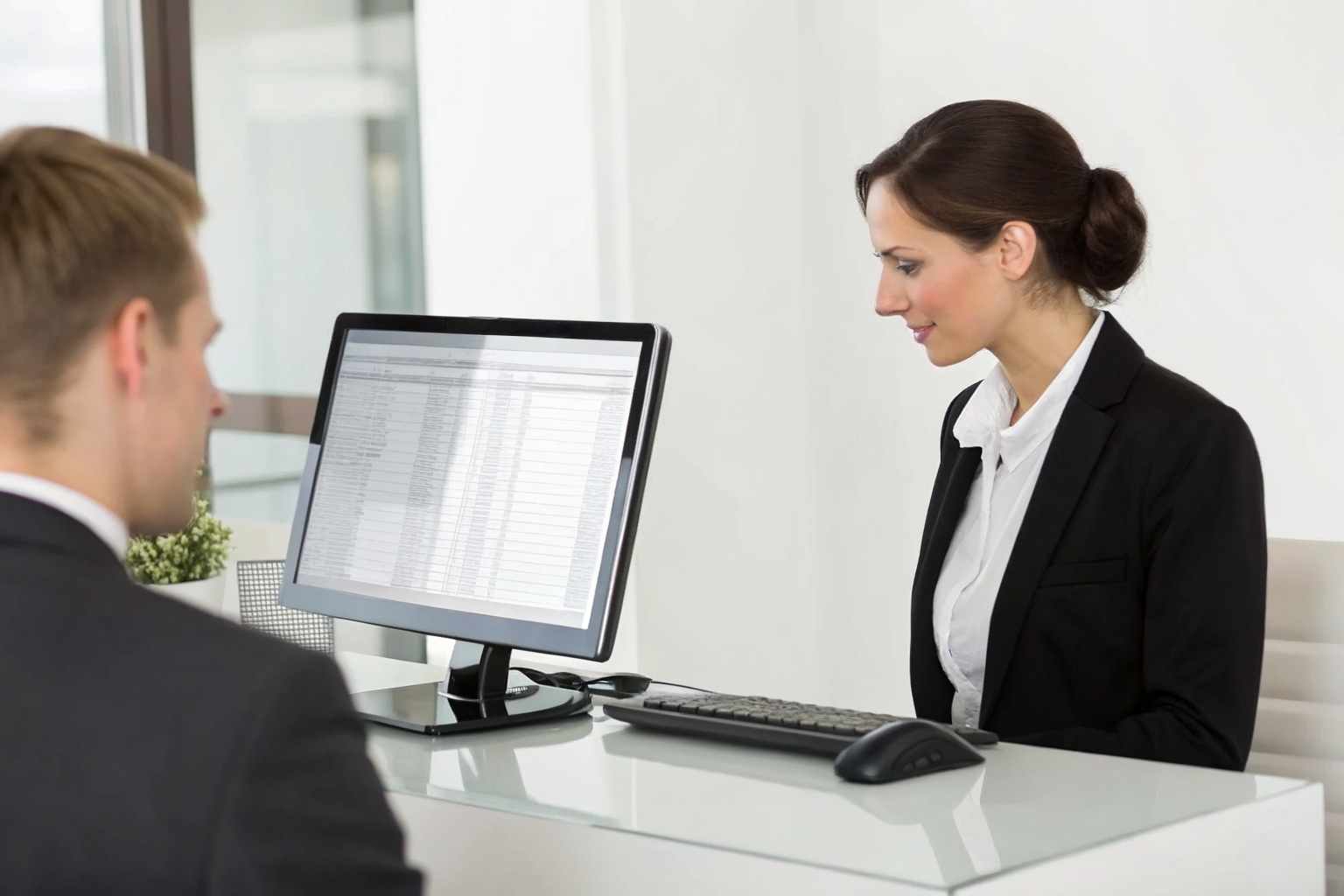 Phoenix receptionist at desk with financial documents on computer screen.