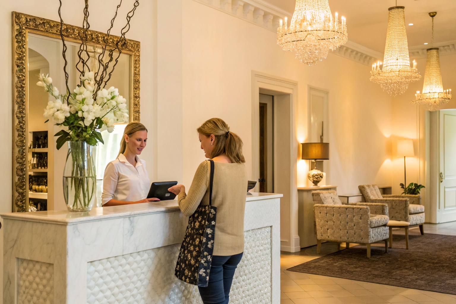 Salon reception with receptionist greeting customer, stylish interior.
